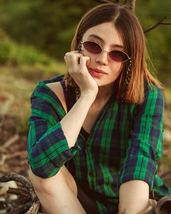 a woman with glasses wearing a green and blue dress