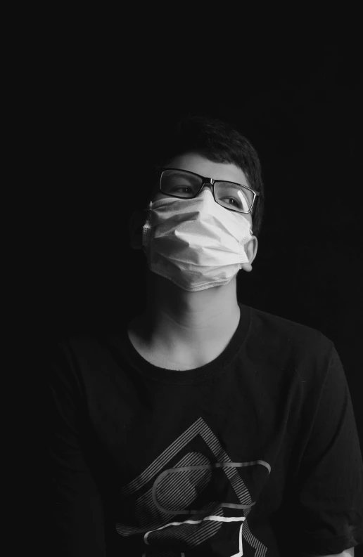 man wearing a face mask while sitting against black background