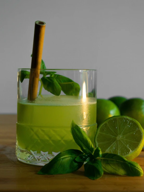 green lemonade with basil and a cinnamon stick in a glass