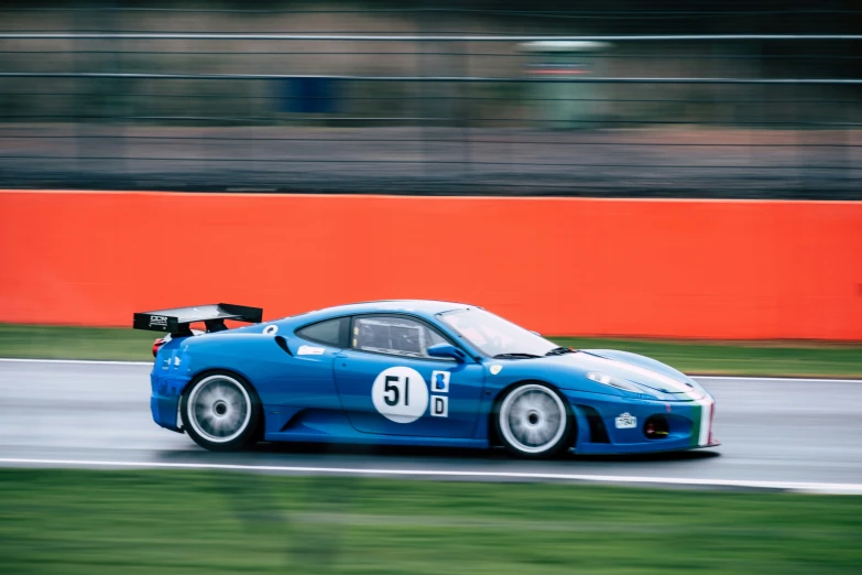 the blue race car drives around the track