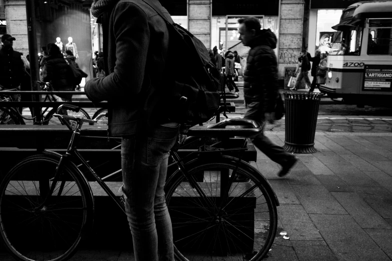 a man looking back as he stands near his bike