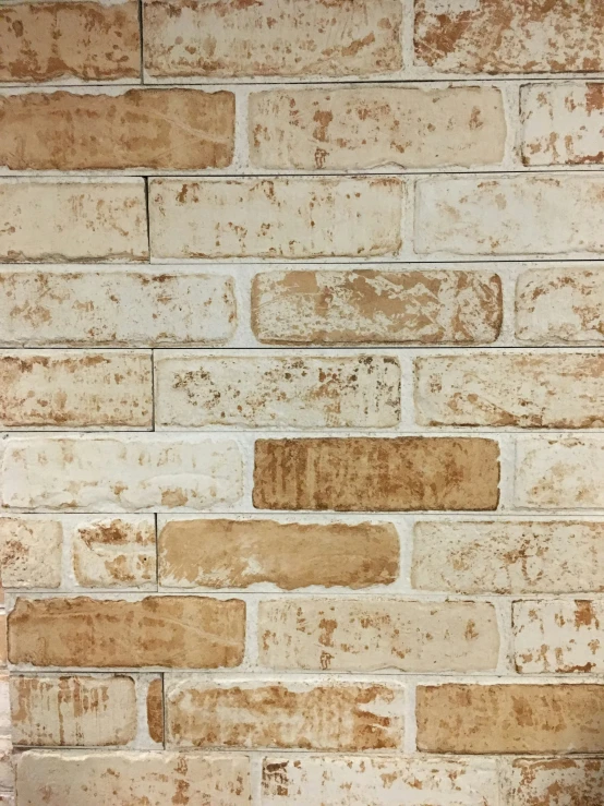 there is a white brick wall that looks like it has faded paint