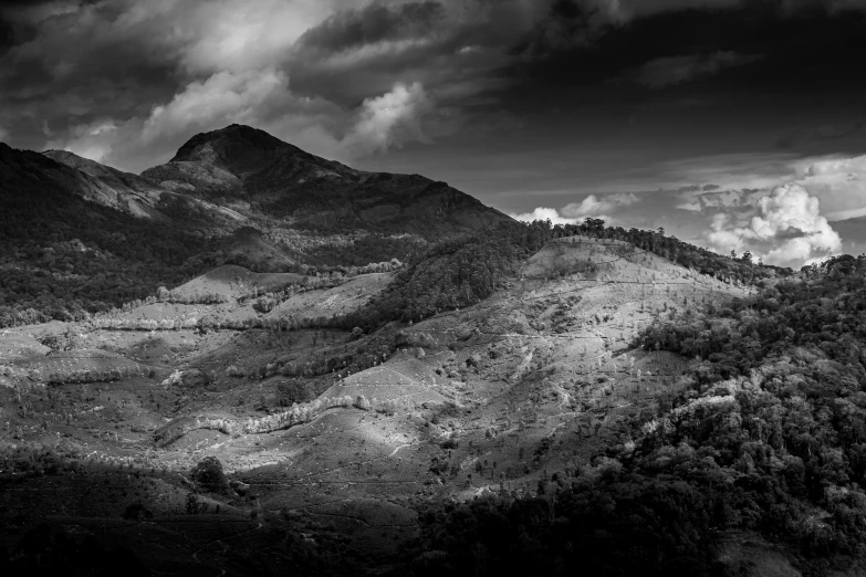 a beautiful view of some hills under cloudy skies