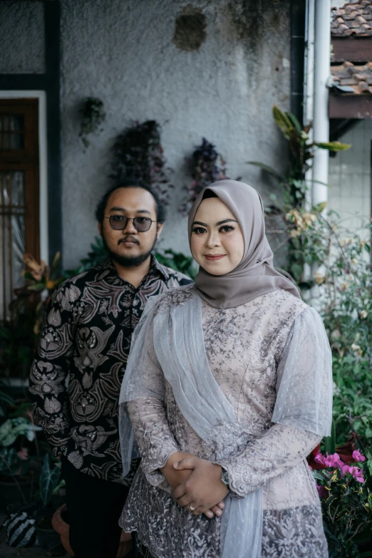 a woman and man are standing in front of the house