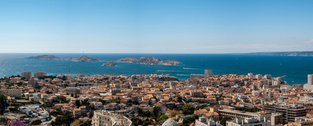 a city next to the ocean with blue skies