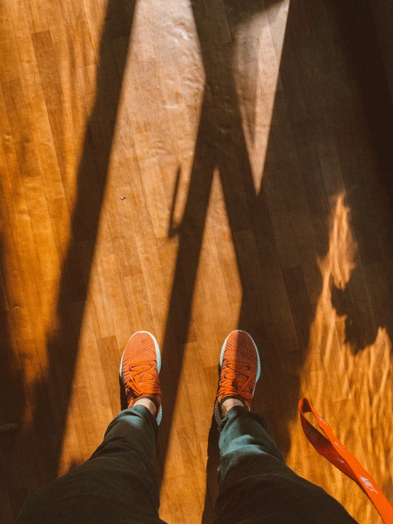 the feet of a man standing next to a clock