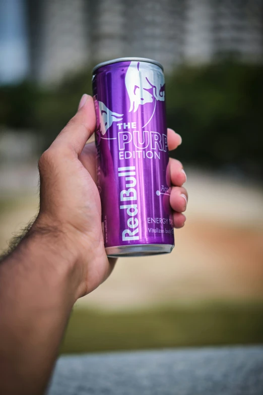 a person holding up a can of beer