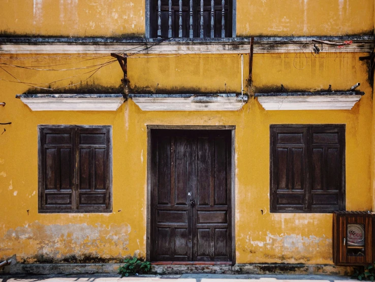 an old yellow building with two wooden doors