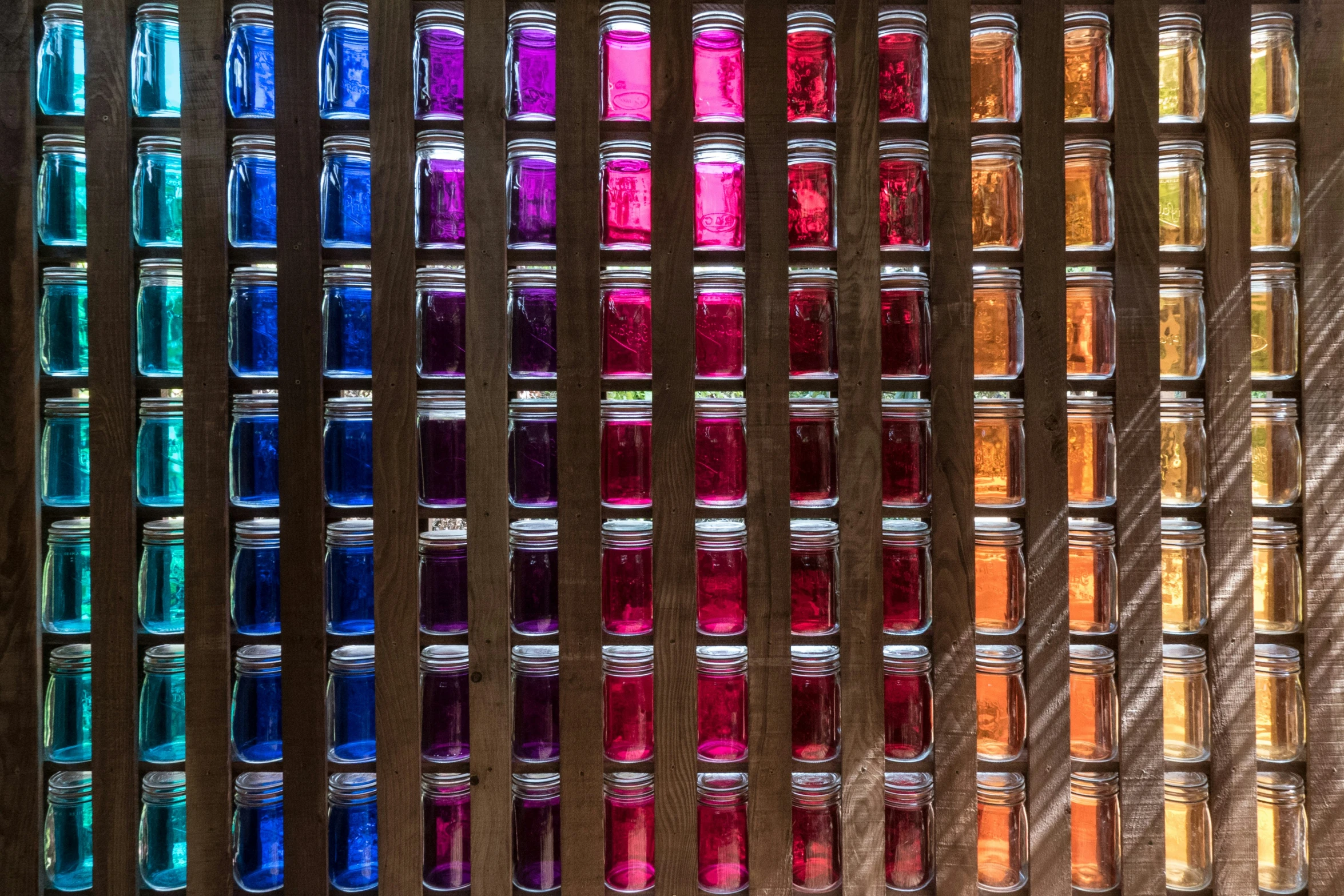 several jars have multi - colored liquids sitting next to each other