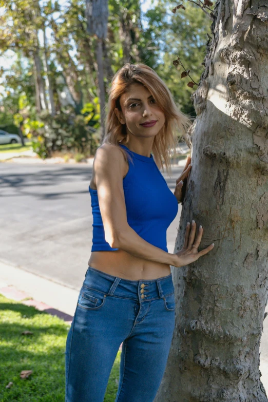 a female standing by a tree posing for the camera