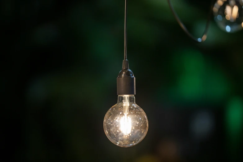 a lit light bulb hanging from a wire