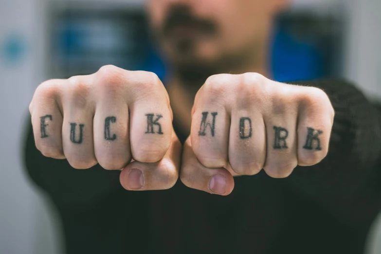 a man with two letters written on his fist and an ink word written on the fingers