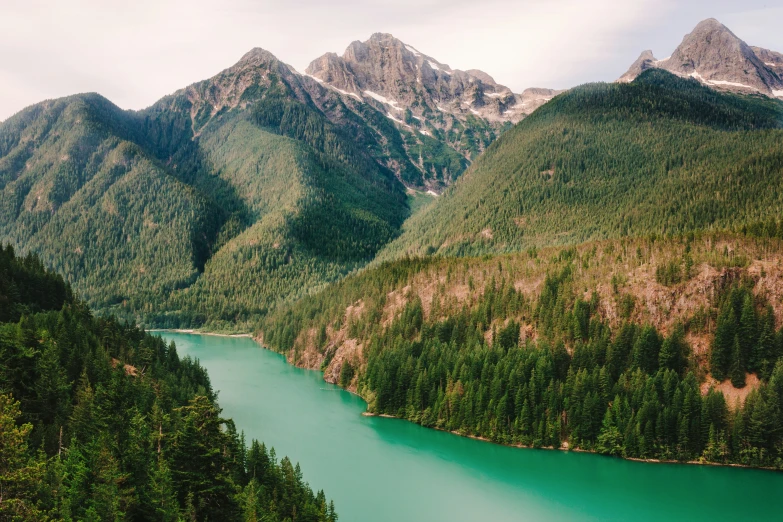 a river in the middle of mountains with green water