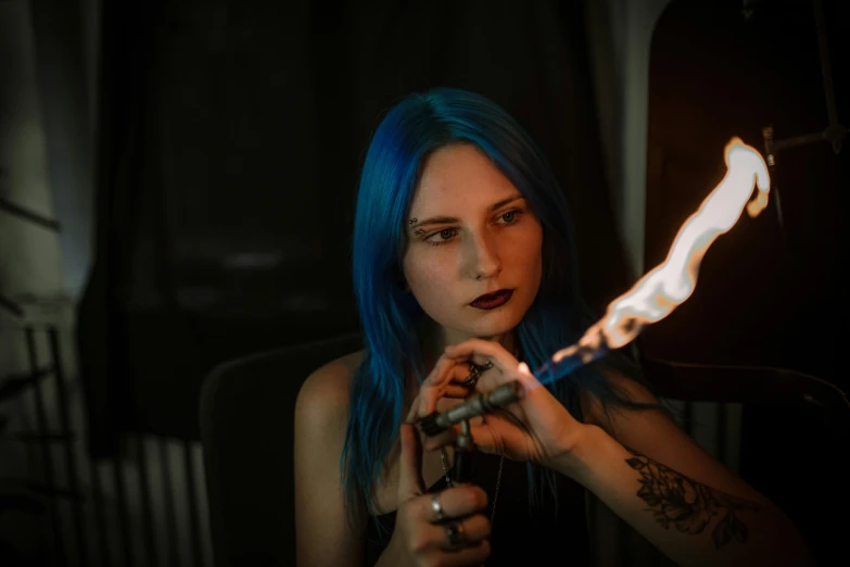 a beautiful woman with blue hair and tattoos holding a cigarette