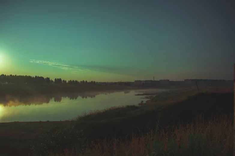 a view from a hill over water and trees