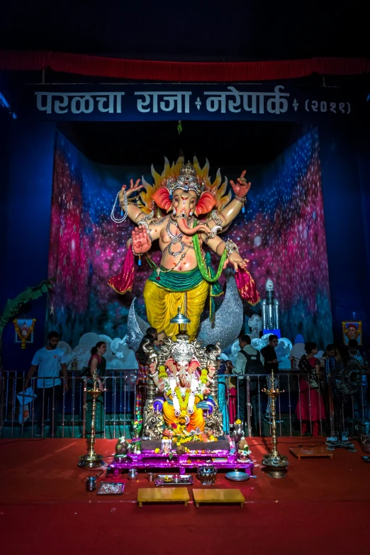 a statue of a hindu god standing behind a fence