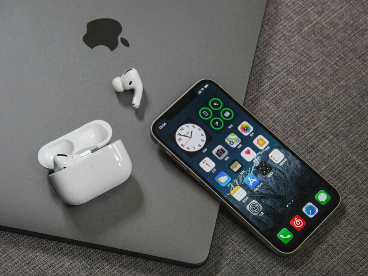 an iphone and ear buds next to the same charging station