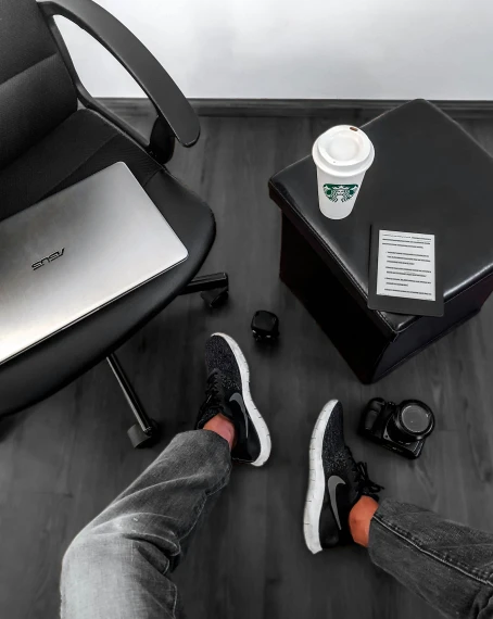 black leather office chair with a desk, laptop, and two shoes