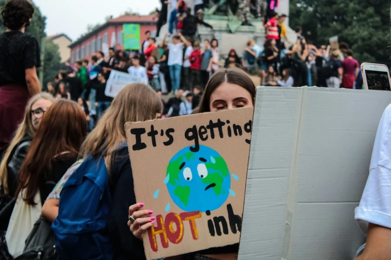 the woman holding a protest sign has an emo face