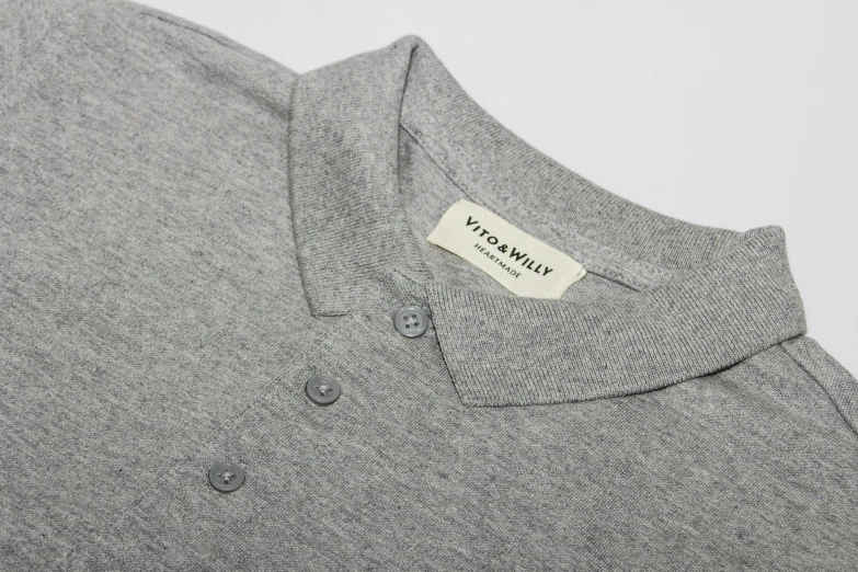 the back of a gray sweater with a tag on it