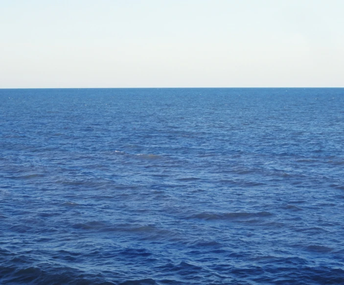 a single small sail boat out in the ocean