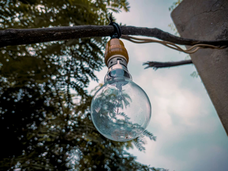 there is an old light bulb hanging from a power line