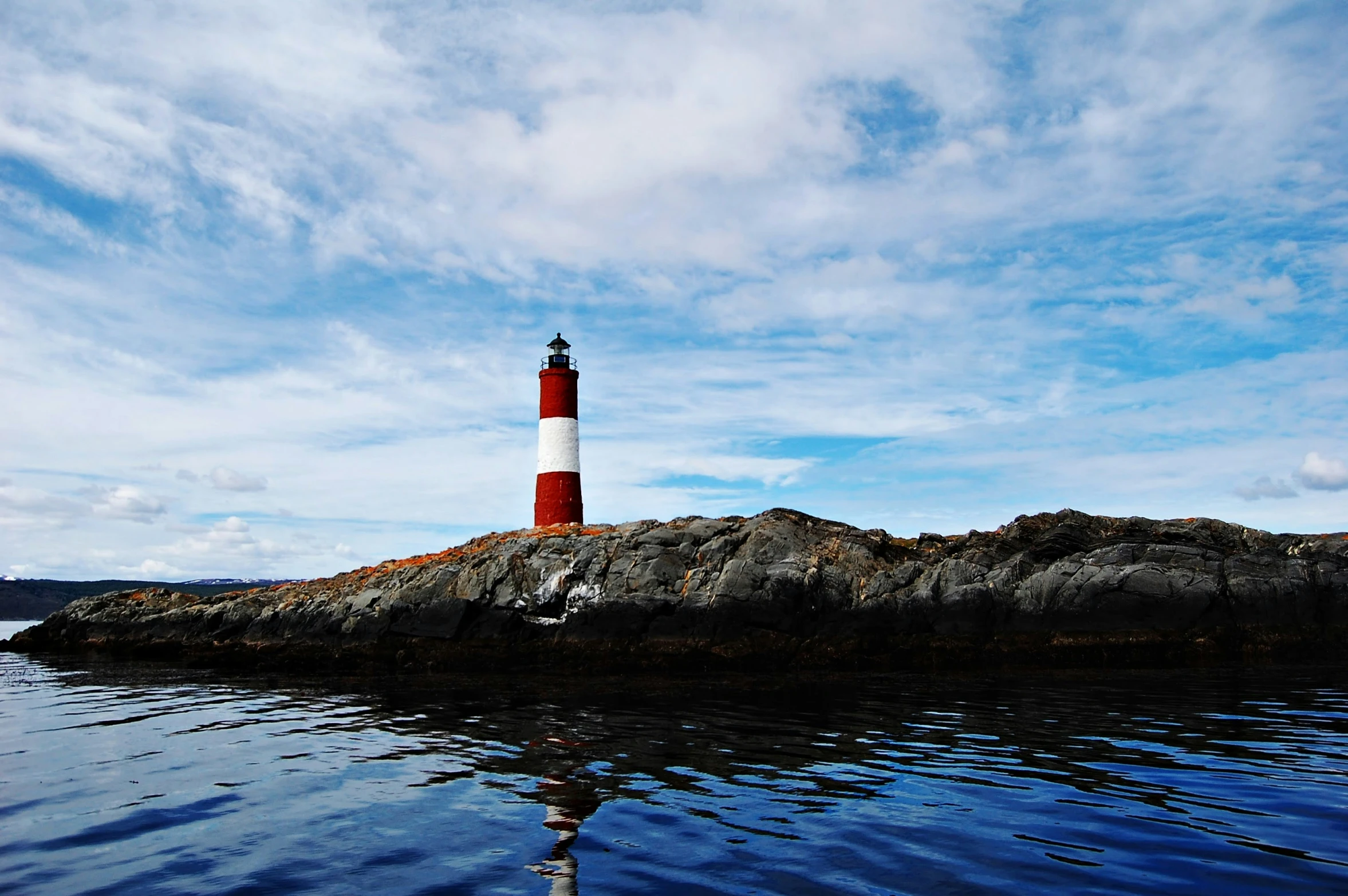 an island with a lighthouse standing in the middle