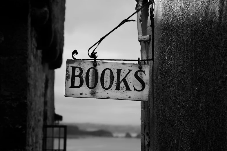 the sign reads books on it hanging from the wall