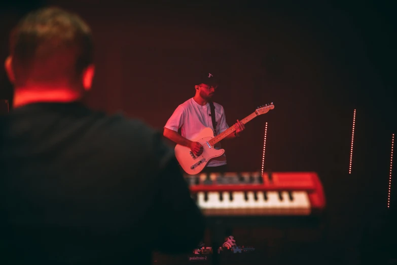 the man is playing an electric guitar on the stage