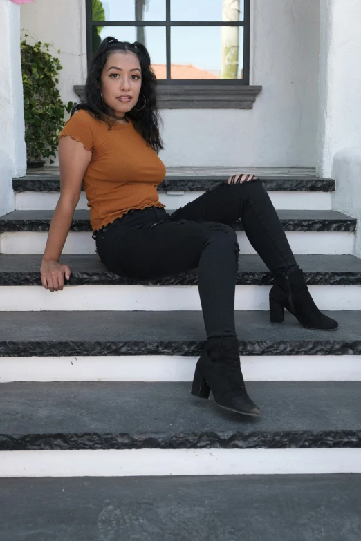a woman sitting on top of stairs looking into the camera