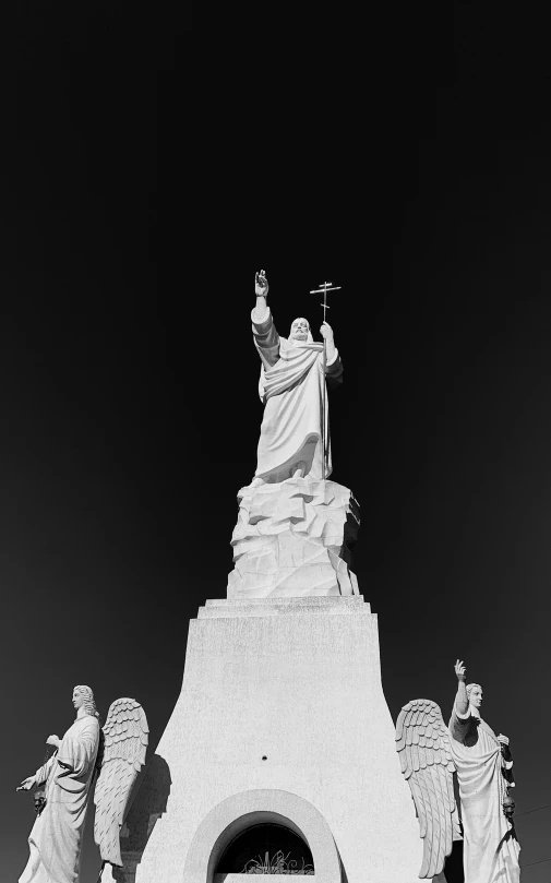 statue in a cement arch that is surrounded by three statues