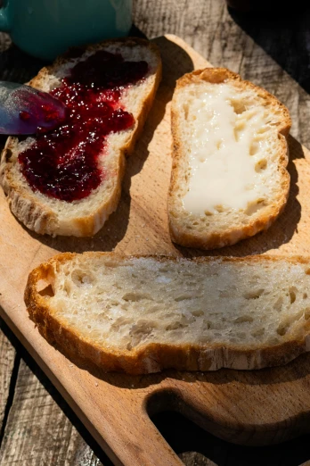 a wooden  board with two slices of bread and jam on top