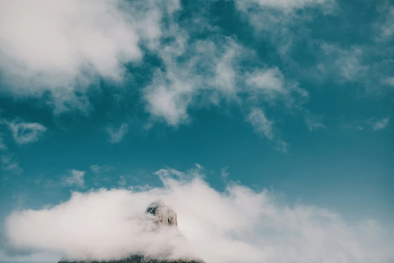 a mountain peak covered in thick fog and clouds