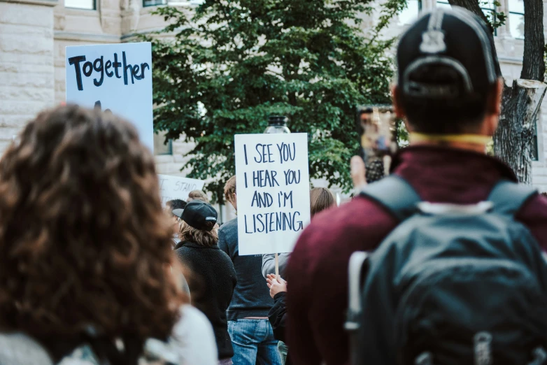 a man and a woman holding a sign that reads i see you there and there i hate my life