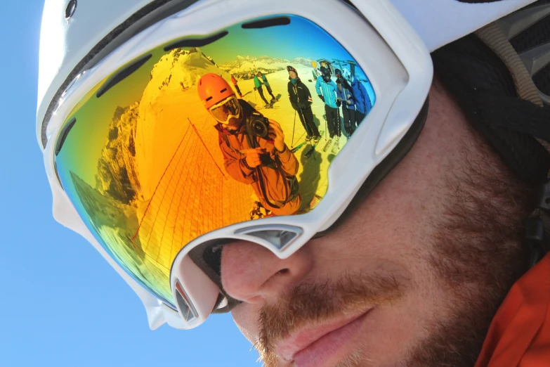 man wearing ski goggles and orange jacket in the sun