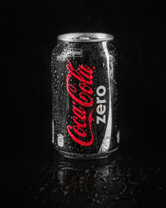 a can of coke in the dark with red writing