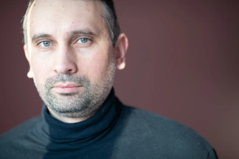 a man who is wearing a neck tie looking at the camera