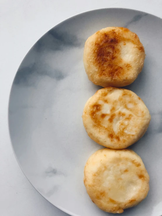 three pancakes sitting on top of a white plate