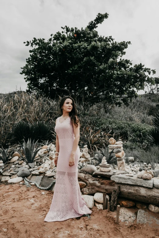 the woman is posing next to a large tree