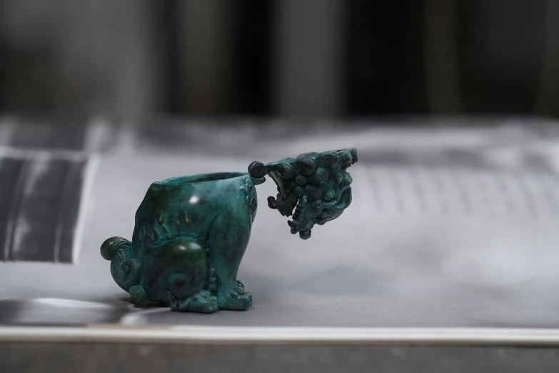 a green vase sitting on top of a counter