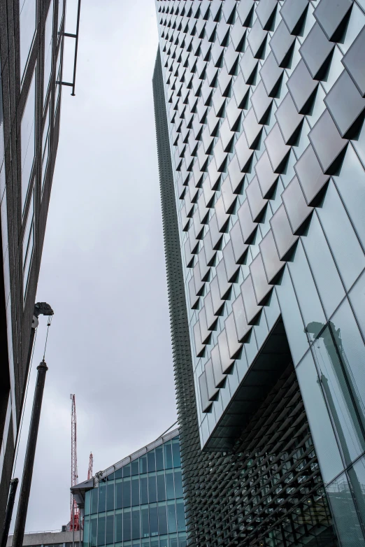 a tall glass building sitting next to a building under construction