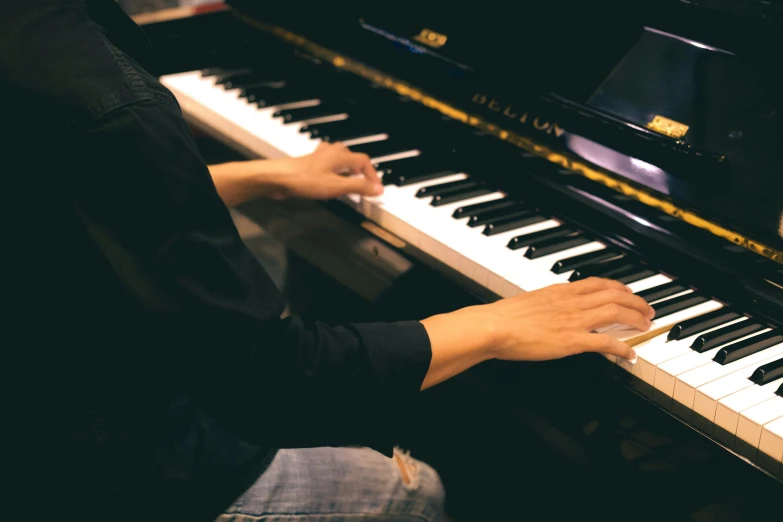 a person is sitting and playing a musical keyboard