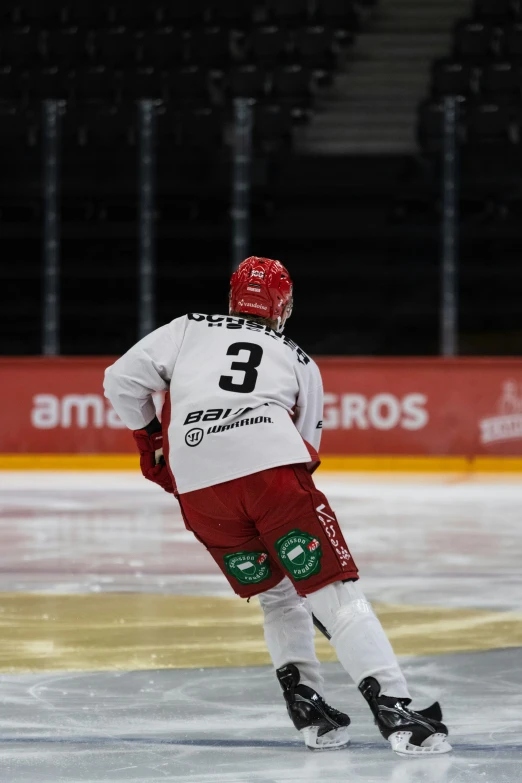 a man is wearing red and white on a skating rink