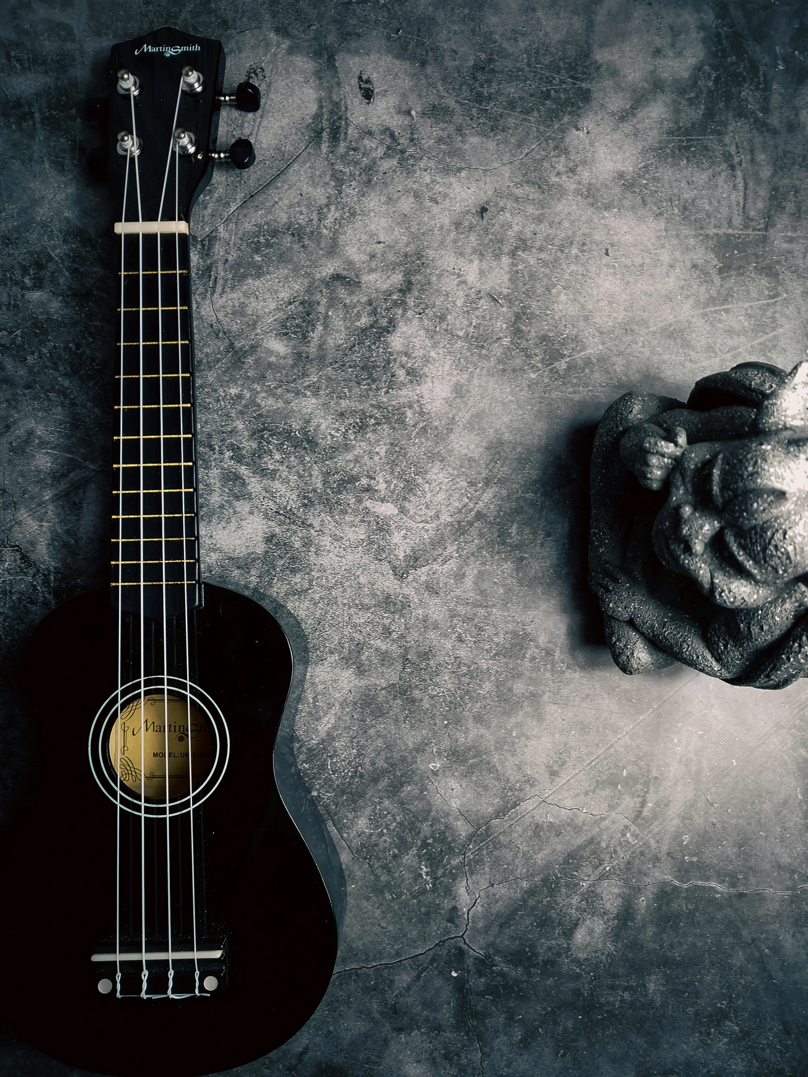 an acoustic guitar leaning against a stone wall