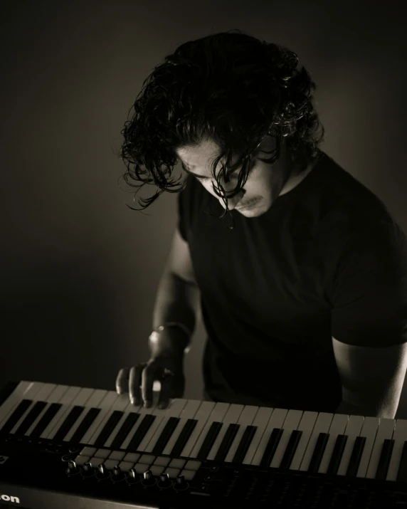 a black and white image of a man playing piano