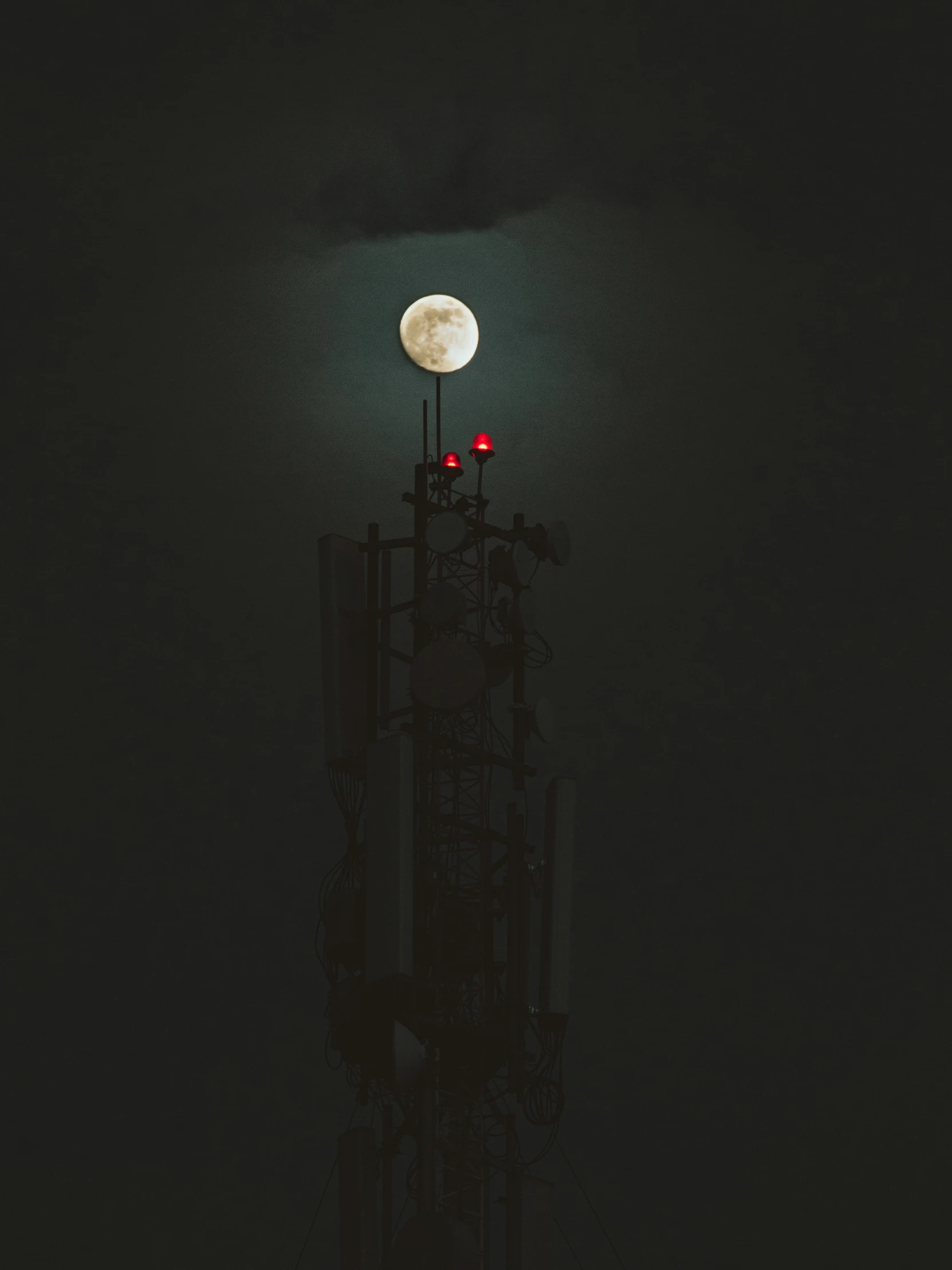 a tower with antennas in the dark sky