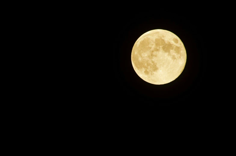 the full moon is visible in the night sky