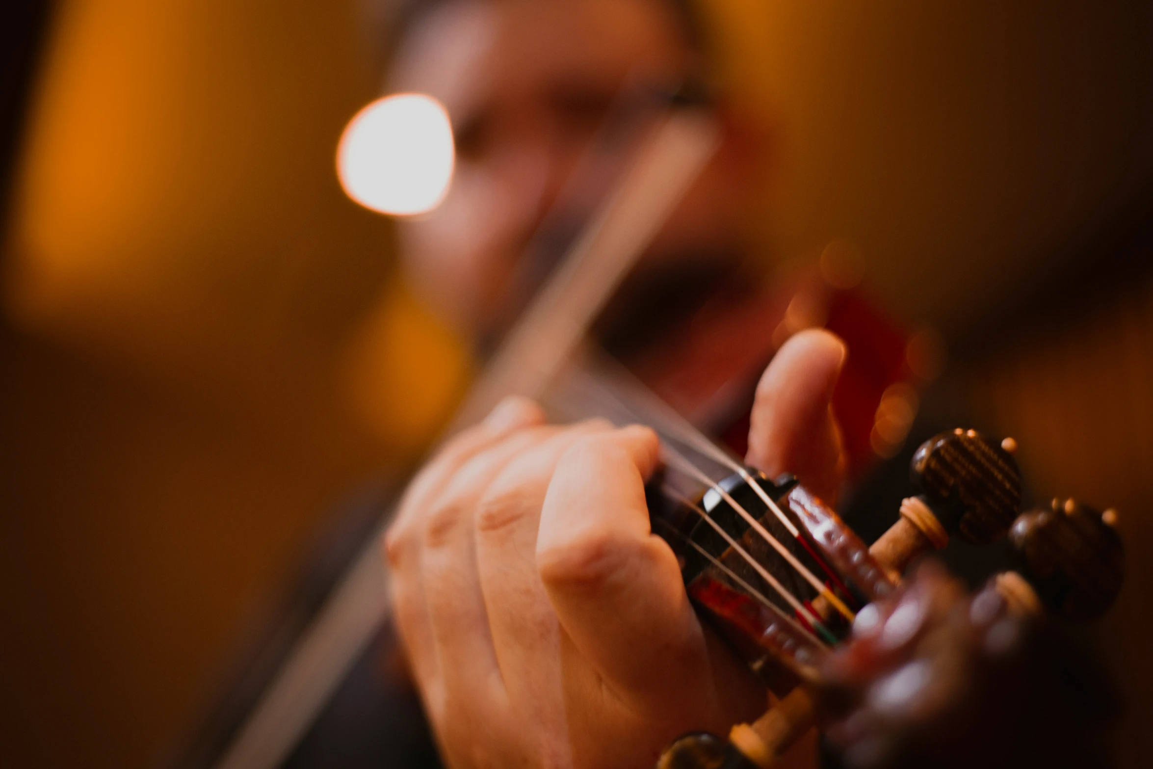 a man plays the violin with one hand and two strings