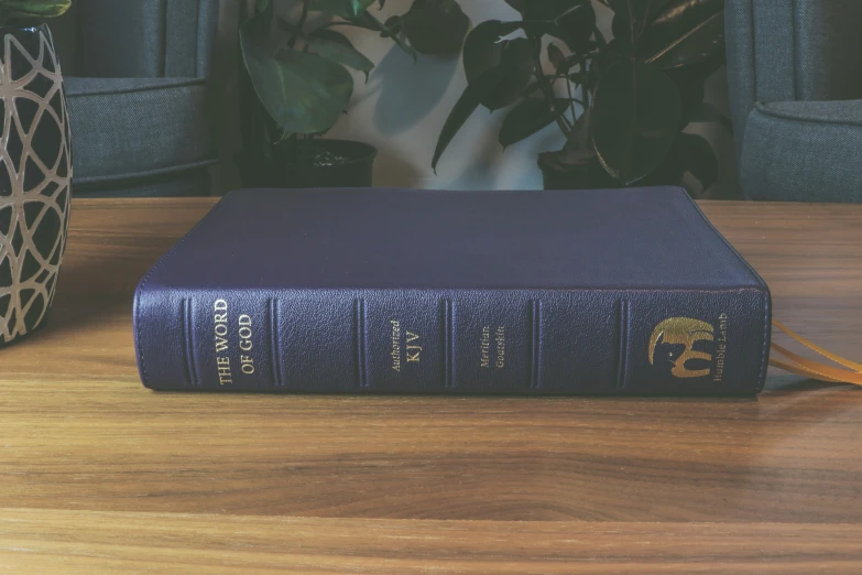 an old book is sitting on the table with a pen