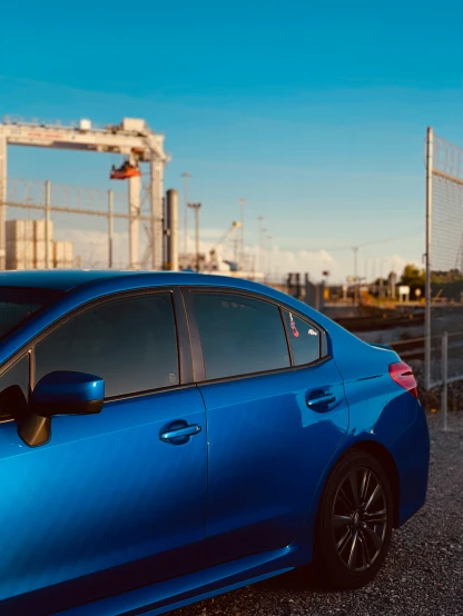 the blue car is parked outside of a construction area